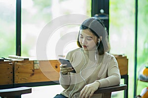 Asian girl listening to music in the coffee shop