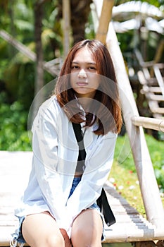 asian girl long hair sitting on the bamboo bridge on weekends Time to go to the cafe