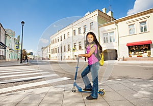 Asian girl with long hair stands on scooter