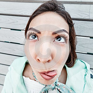 Asian girl make funny faces. Millennials emotions. Wide-angle optics and fisheye distortion