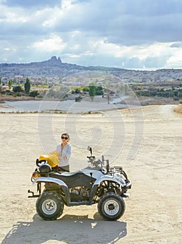 Asian girl making up bags by an ATV in Cappadocia`s valley