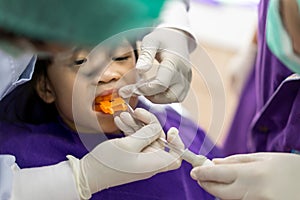 Asian girl met the dentist for routine dental checkup and fluoride treatment.