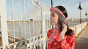 Asian girl in the national costume and the Vietnamese Ao Dai dress walks along the embankment Da Nang