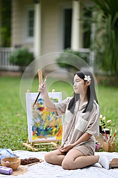 Asian girl painting with watercolor at outdoor.