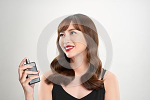 Asian girl with perfume, young woman applying perfume on her wrist and smelling