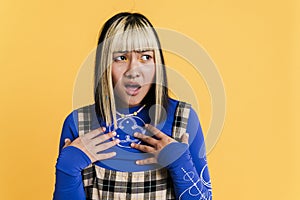 Asian girl with piercing exclaiming while gesturing at camera