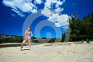 Asian girl in pink bikini dancing at the tropical beach