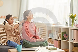 Asian Girl Plaiting Mother`s Hair