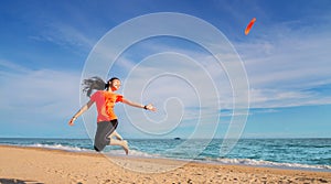 Asian girl play flying disc on the beach