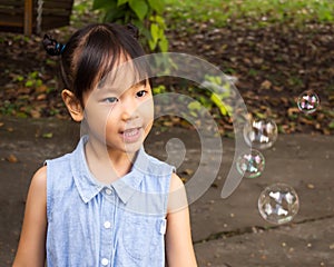 Asian girl playing with blowing bubbles. Funny activity. Natura