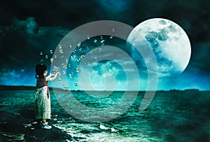 Asian girl playing with soap bubbles. Super moon behind partial cloud on sky