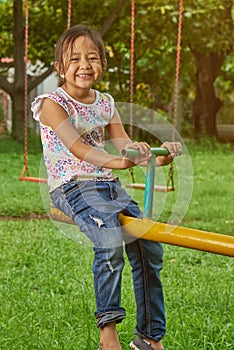 Asian girl playing on a teetertotter