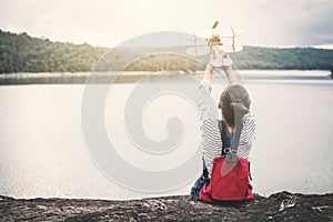 Asian girl playing wooden plane in nature