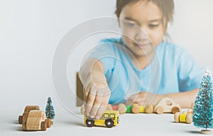 Asian girl playing wooden toys on white background.
