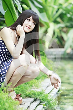 Asian girl in pond edge