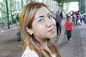 Asian girl posing on crowded with people street