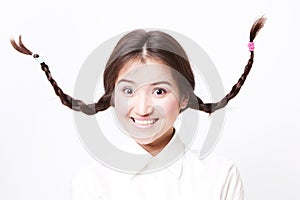 Asian girl pulling funny face with pigtails going up in the air