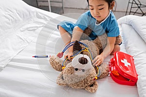 asian girl putting toy stethoscope on