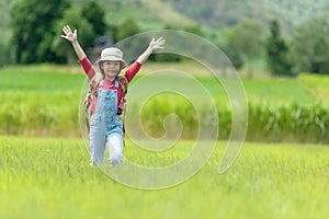 Asian girl raise arms and jumping on the green meadow outdoors adventure. People kid tourism  traveling education nature forest fo