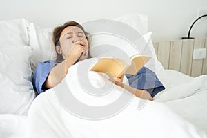 Asian girl Read books while sleeping. Man book cover Drowsiness causes sleep.The concept of adequate sleep. Good sleep