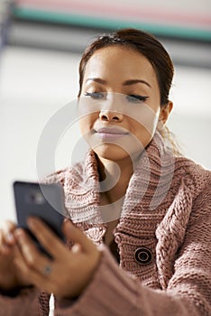 Asian girl reading sms on smarthphone