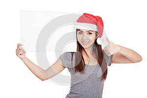 Asian girl with red santa hat thumbs up with a blank sign