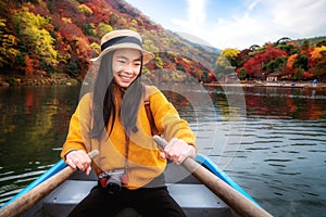 Asian girl relax by paddle and a rent boat on river in arashiyama park