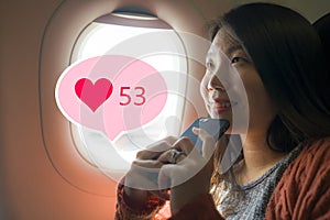 Asian girl sharing travel experience on social media . young happy beautiful Korean tourist woman in airplane cabin getting