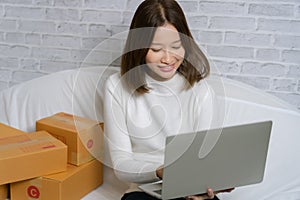 Asian girl shop online are answering the customer email for delivery