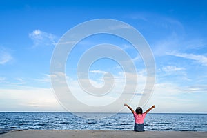 Asian girl sits on the cliff near the sea