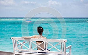 Asian girl sitting in chair watching the sea