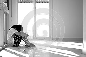 Asian girl sitting on floor at home. Bullying and isolation concept.