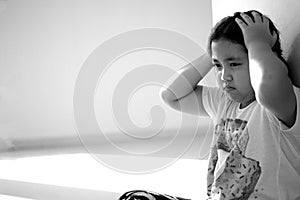 Asian girl sitting on floor at home. Bullying and isolation concept.