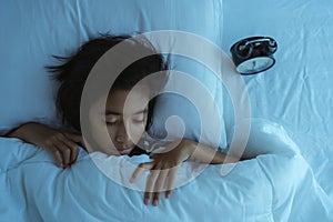 Asian girl  sleeping on the bed at midnight. Inside the bedroom is dark  little girl deep sleep