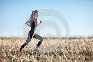 Asian girl in sportswear running across field, morning workout