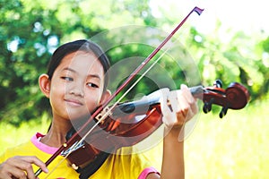 Asian girl standing with violin smiles happy.