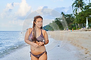 Asian girl stands on the beach - an afro pigtails near a tanned girl