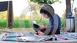 Asian girl of student dress doing homework in countryside.Child education and countryside life concept, Rural india