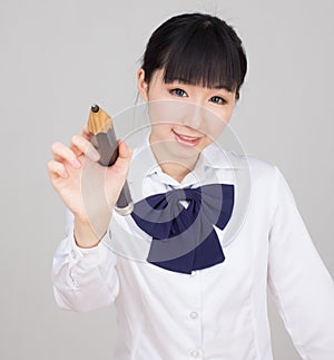 Asian girl student in school uniform studying with an oversize pencil photo