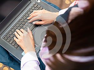 Asian girl student in school uniform Thailand style using laptop in the park