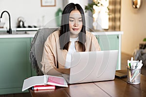 Asian girl studying at home, distance education concept. Female student learning with laptop. Young woman working remote