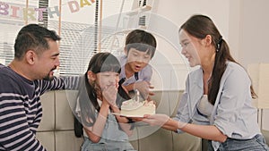 Asian girl is surprised with birthday cake and celebrates party with family.