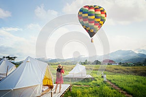 Asian girl take a hot air balloon photo by camera in Countryside homestay