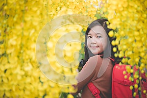 Asian girl take photo with blooming yellow flower