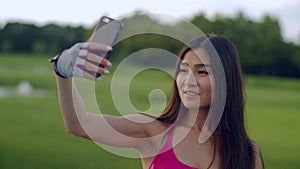 Asian girl taking selfie in park. Sport girl selfie on phone in park
