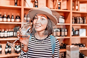 Asian girl tasting red wine at the winery