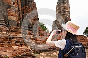 Asian girl tourist taking photo of ancient of pagoda temple