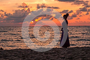 Asian Girl in Traditional Dress Watching the Sunset on the Beach