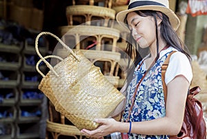 Asian girl, travel and shopping in traditional basketry shop photo