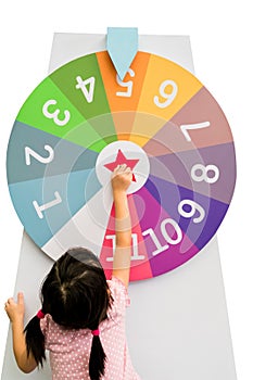 Asian girl trying to spin the huge colorful fortune wheel with w